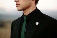 10 a black suit, a black shirt, an emerald tie and a silver badge instead of a boutonniere