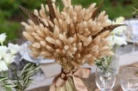 10 a traditional fall centerpiece of wheat and feathers and a silk brown ribbon