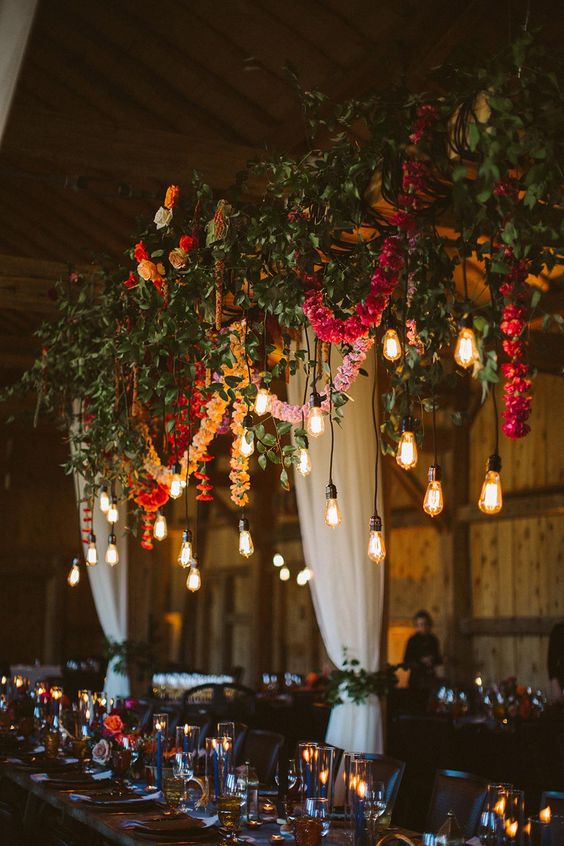 gorgeous overhead wedding decor with fresh greenery, colorful flower garlands and bulbs hanging down