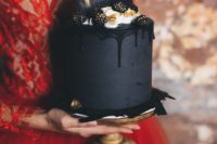 11 a moody matte black wedding cake with black drip, cream, gilded blackberries and black chocolate shards