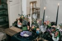 11 a moody wedding tablescape with black table runners and napkins, a textural floral table runner, black candles and puple plates