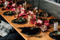 13 a gorgeous boho Halloween table setting with pink and burgundy blooms, black plates and candles and gilded touches