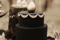 13 a haunted black wedding cake with white touches, berries on the bottom and a silver pear on the top