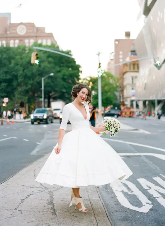 a chic midi wedding dress with long sleeves and a plunging neckline plus cutout wedding shoes