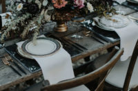 14 a gorgeous haunted tablescape with a lush textural centerpiece, marble chargers, printed plates, gilded touches and white napkins