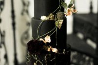 14 a refined black wedding cake with two matte tiers and a textural tier with gold touches, topped with flowers and herbs
