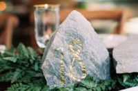 14 a rock table number with gold foil is a cool idea for a mountain wedding