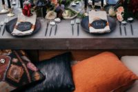 19 a moody boho tablescape with black chargers and candles, lush and bold floral centerpieces, antlers and feathers