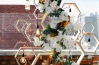 20 a bold modern wedding backdrop of hexagons, lush blooms and Edison bulbs all over