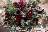 21 a moody Halloween centerpiece with deep purple and burgundy blooms, berries, textural greenery and foliage