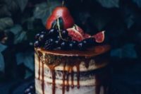 23 a decadent Halloween semi-naked wedding cake with caramel drip and berries and fruits on the top