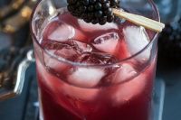 24 black window cocktail  of juice and vodka served with a blackberry