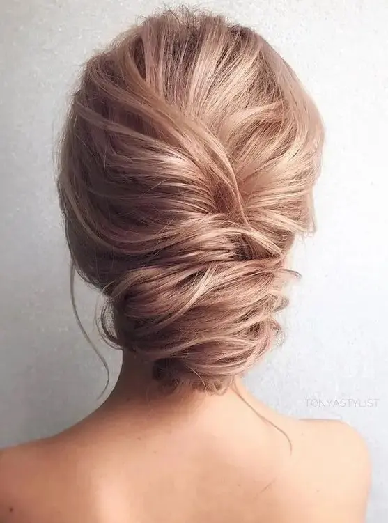 a French twist low updo with a messy look and texture for an elegant yet effortless look