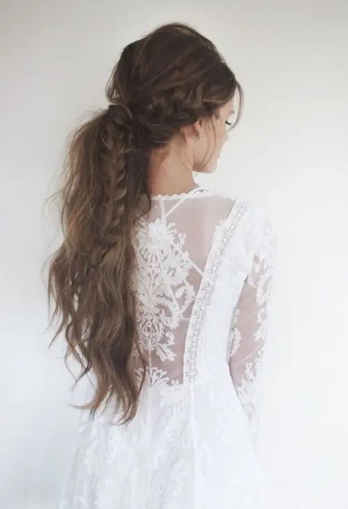 a boho chic low ponytail with several braids, textural waves down and a volume on top looks super boho and wild
