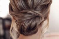 a chic fishtail braid low bun with a messy volume on top and some locks down is amazing