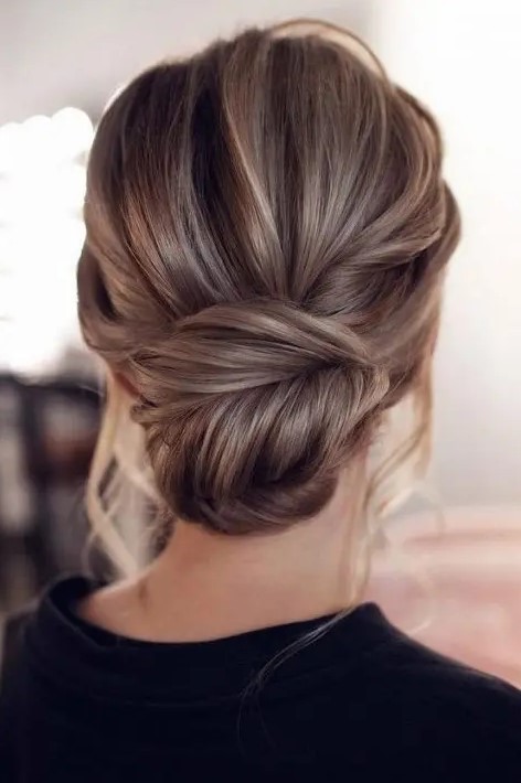 a chic fishtail braid low bun with a messy volume on top and some locks down is amazing