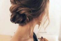 a chic twisted low bun with a small bump and some locks down for a timelessly romantic look