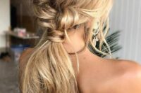 a cool twisted messy ponytail with a braid and a messy top plus textural hair and face-framing locks