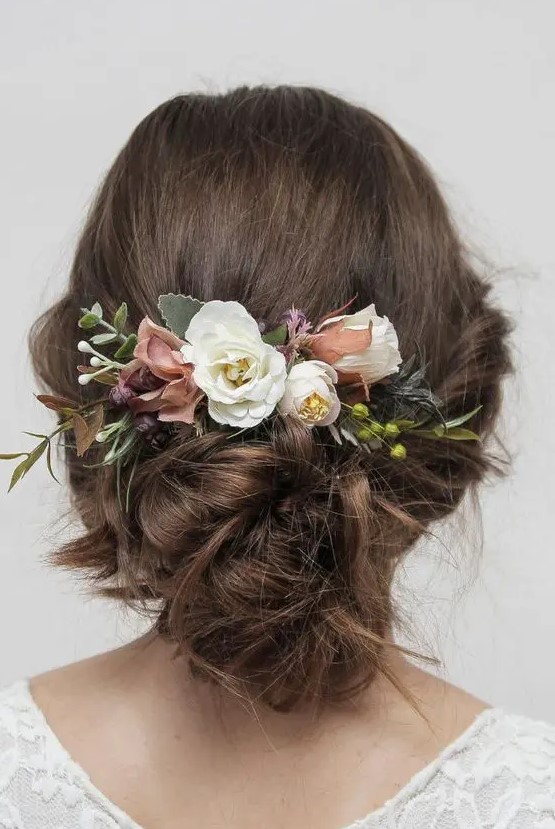a delicate wedding updo witha bit of mess and waves, with neutral and dusty pink blooms and berries is a cool idea