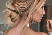 a lovely messy and wavy low updo with a volume on top, some locks down and a twisted low bun is a gorgeous idea for a modern bride or bridesmaid