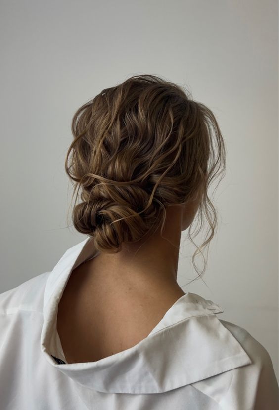 a lovely wavy messy low bun with a wavy top and some locks down is a perfect solution for a bridesmaid with long hair