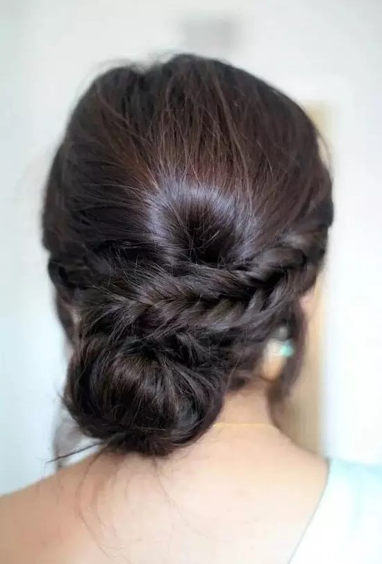 a low bun with a side braid and a bump for a whimsy take on a usual low bun hairstyle