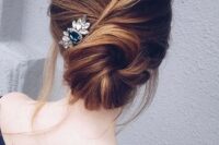 a messy twisted low chignon hairstyle with some bangs and a large hairpiece on one side for a relaxed look