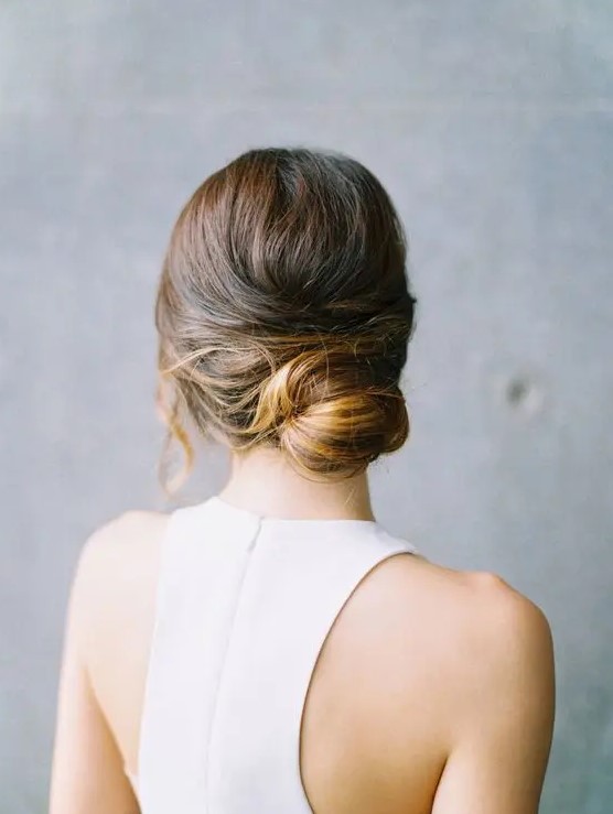 a modern low bun with a bump and locks down is a refined and elegant hairstyle for a minimalist bride or bridesmaid