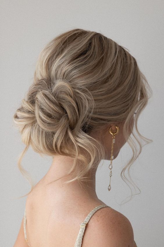 a pretty messy wavy low bun with a bit of volume on top, some locks down and face-framing hair