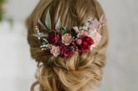 a refined low updo with twists and some waves down and bold blooms – fuchsia, blush and pink flowers, greenery