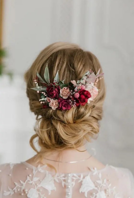 a refined low updo with twists and some waves down and bold blooms - fuchsia, blush and pink flowers, greenery