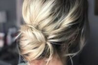 a simple and elegant low bun with a volume on top, some locks down is a stylish idea with twisted touches