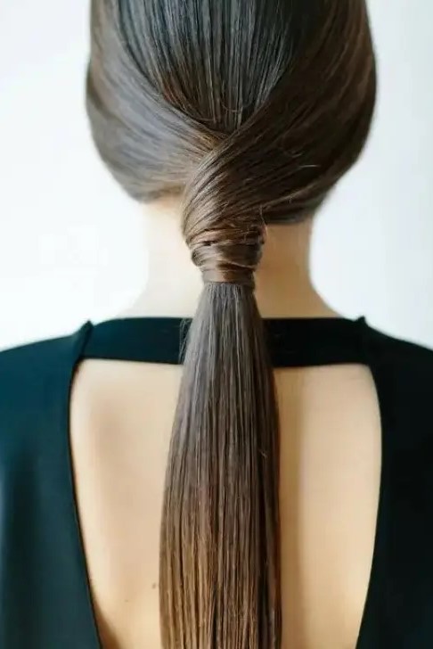 a sleek twisted low ponytail is a stylish idea for a modern or minimalist bride or bridesmaid
