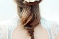 a twisted and relaxed bridal ponytail with a pearly hairpiece for a beach bride who is looking for elegant and sleek styles