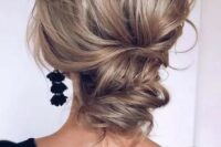 a wavy and chic low updo with a volume on top and some waves is a cool option for a modern refined bride