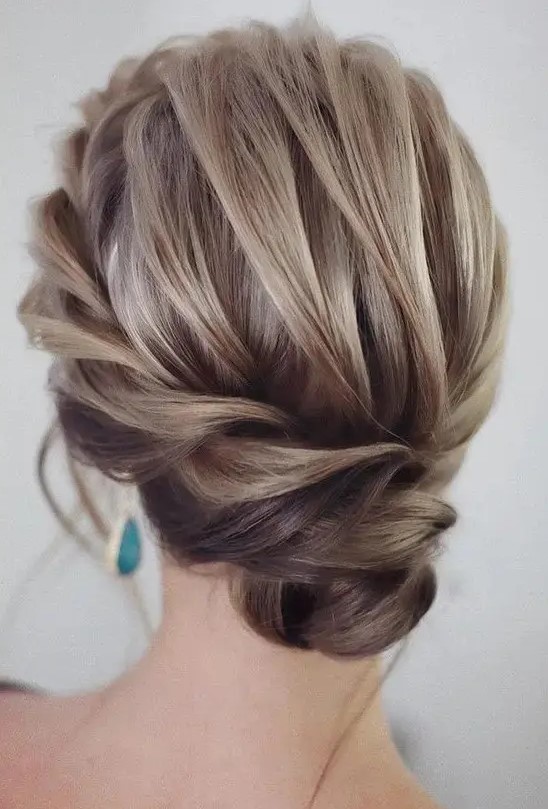 an exquisite low bun with a braided halo and a voluminous top plus locks down is very chic