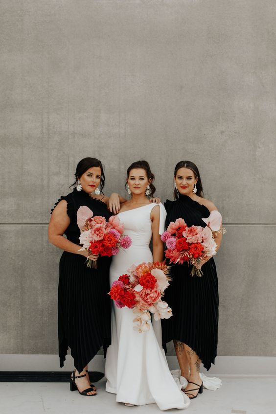 beautiful and sophisticated black one shoulder midi bridesmaid dresses with asymmetrical skirts, black shoes and statement white earrings