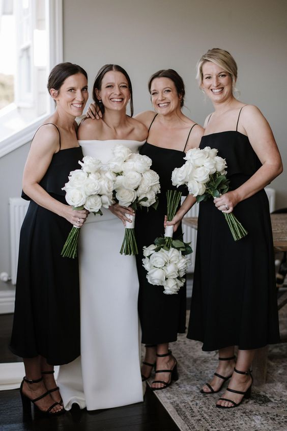 Chic modern black midi A line bridesmaid dresses with spaghetti straps and black strappy shoes for a minimalist wedding