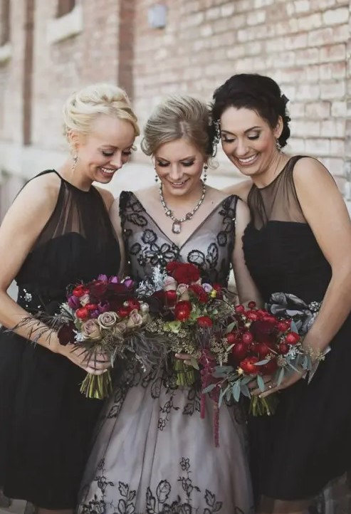 elegant midi black A-line bridesmaid dresses with illusion necklines and draped fabric look chic and stylish at a Halloween wedding