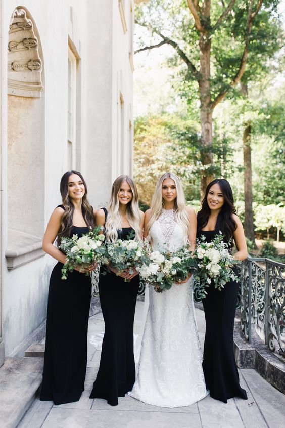 matching black mermaid maxi bridesmaid dresses with straps and with small trains are grear for a modern boho wedding