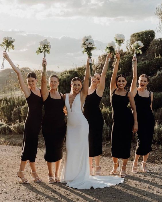 matching black midi bridesmaid dresses with thick straps, white strappy shoes are perfect for a modern or minimalist wedding