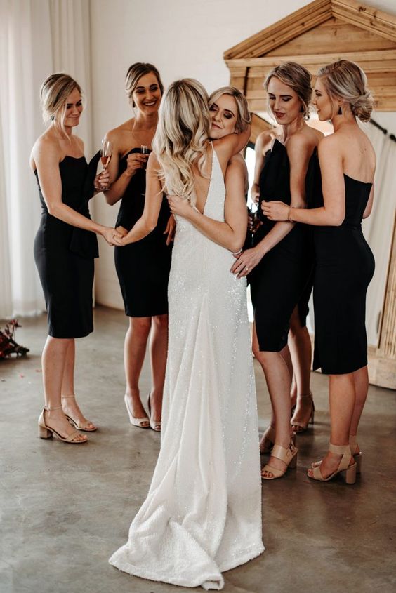 matching midi black knee bridesmaid dresses and nude shoes are perfect for a modern wedding
