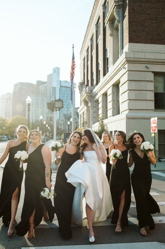 mismatching maxi black bridesmaid dresses with straps and one shoulder ones, with slits and neutral shoes for a chic summer wedding
