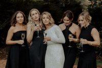 mismatching midi black bridesmaid dresses and black strappy shoes are a great combo for a boho wedding