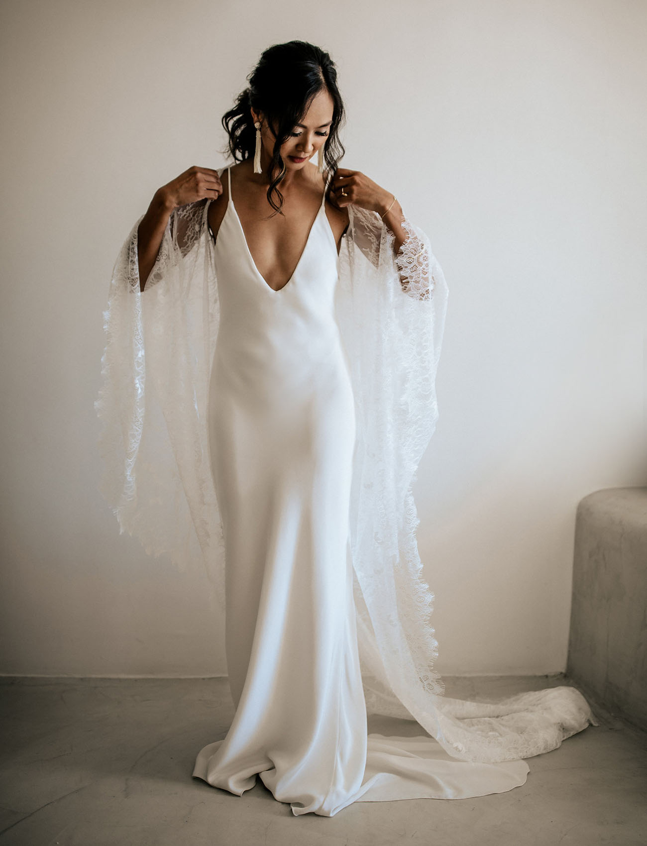 The bride was wearing a plain spaghetti strap wedding dress with a plunging neckline and an ethereal coverup