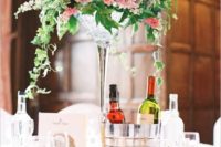 02 a chic wedding centerpiece of pink roses and cascadig greenery in a glass vase for a cool look