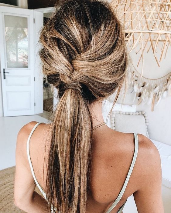 a loose braid into a ponytail is a cool idea for a boho or rustic wedding