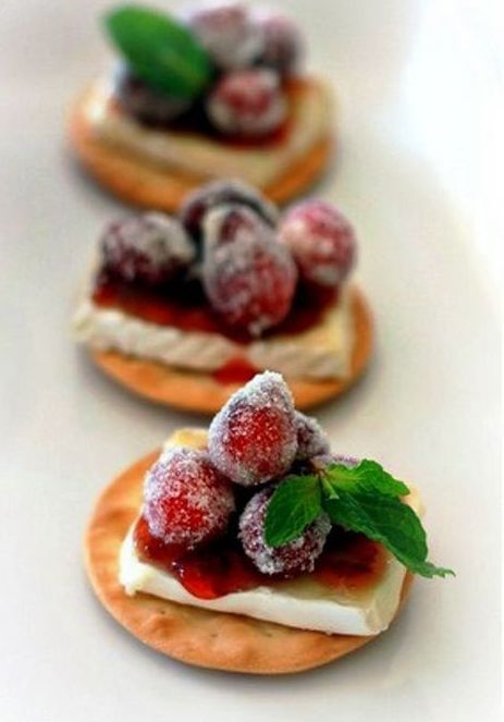 tasty little bites of crackers, cheese, jam and sugared berries on top