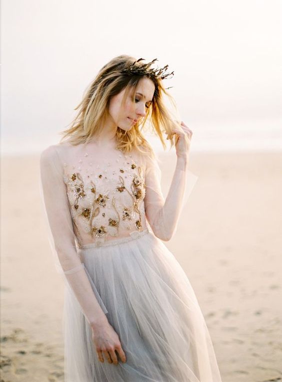 a neutral wedding gown with sheer parts and an embroidered and embellished bodice