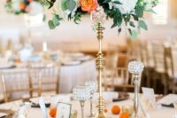 05 a cute tall wedding centerpiece with white hydrangeas, orange roses and greenery and citrus on the table